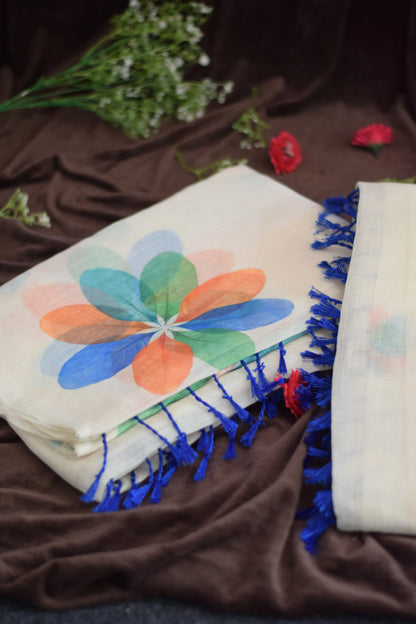 Thennal_Ice cream saree -Abstract Overlapping Petals_saree from thambai.Two scarves with colorful floral patterns and blue tassels on a brown fabric background.