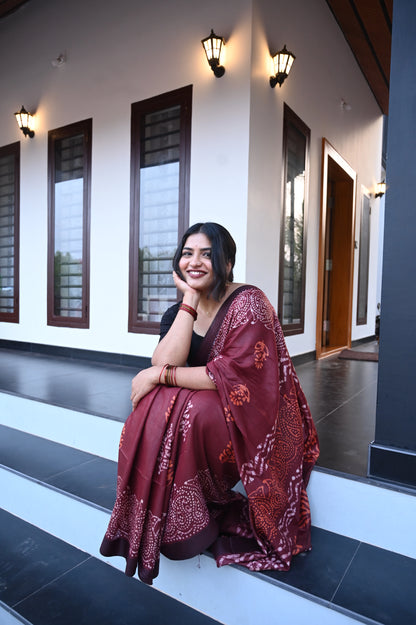Woman in Sindoora_Chungudi Saree from saree from thambai  sitting on steps outside a building.